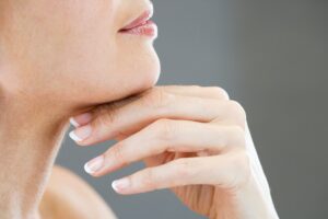 Close-up of the mouth of a woman, shown in profile, who is resting her jaw on her hand